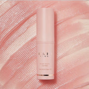 Pink skincare bottle with 'Kahi' branding on a textured pink background