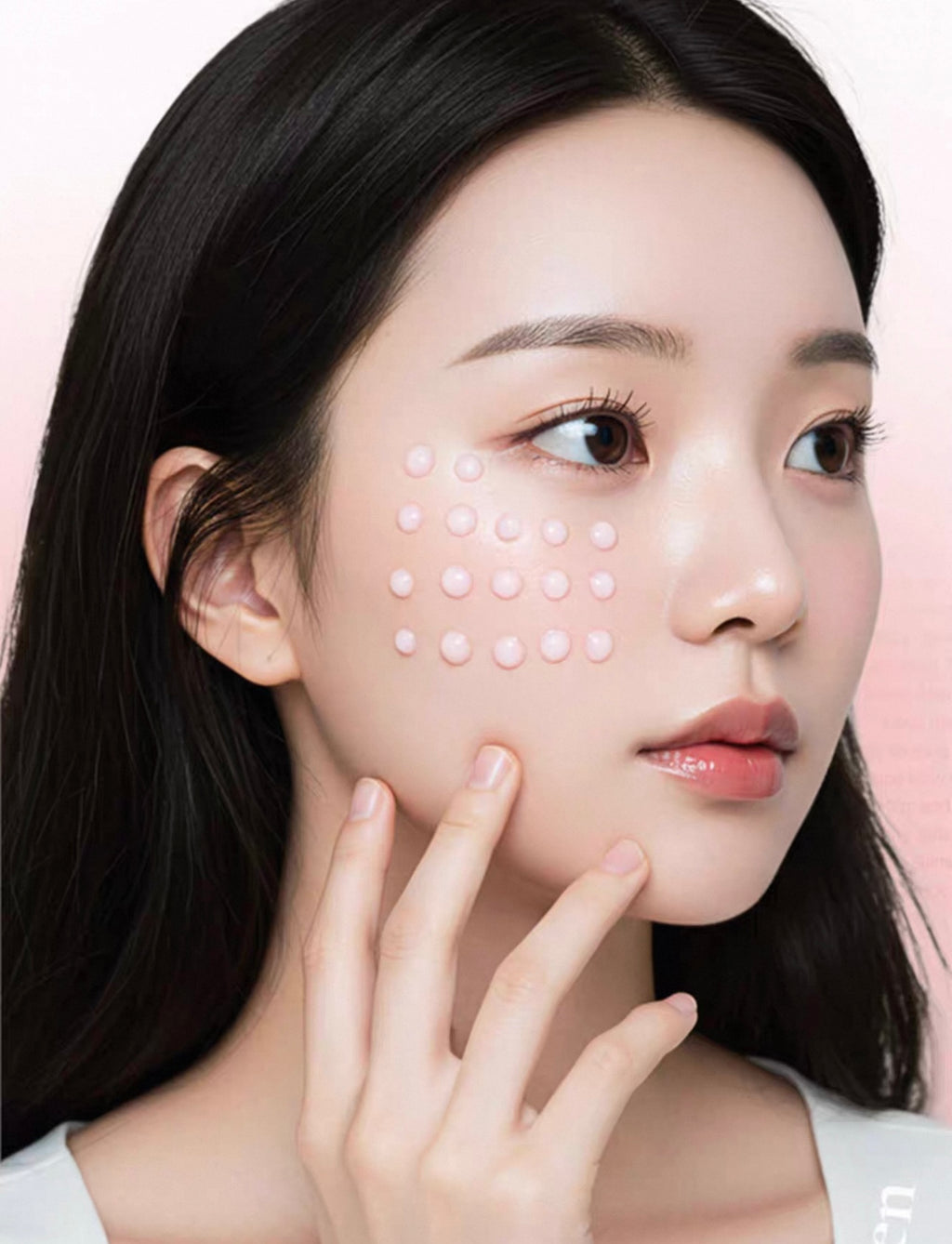Woman with dots on her face against a pink background