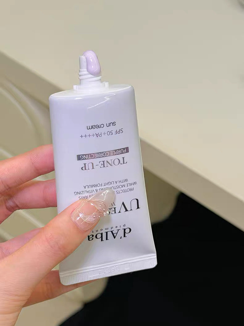 Hand holding a white skincare product packaging with visible branding on a neutral background