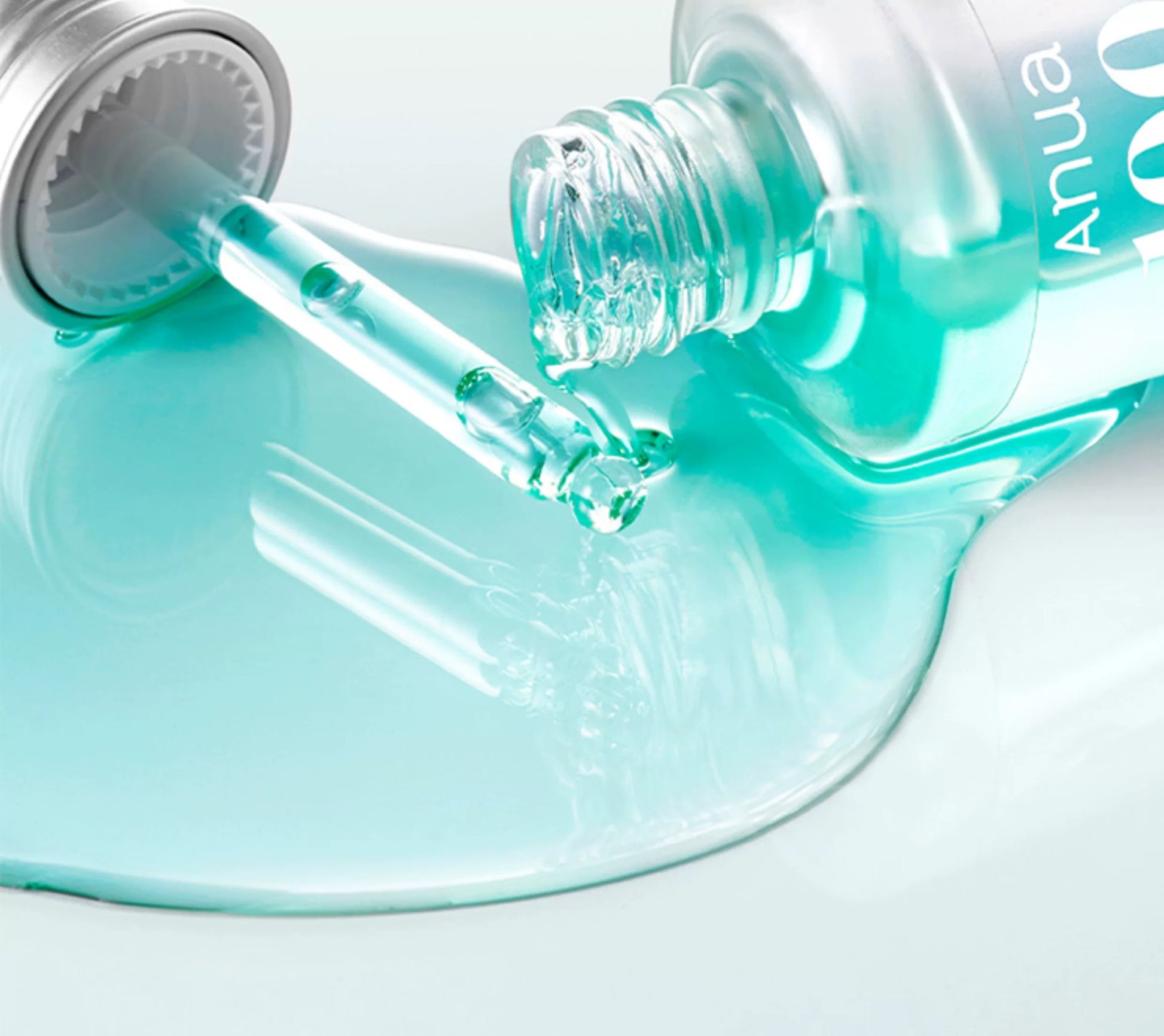 Close-up of a dropper with teal liquid on a white background, featuring the product 'Anua 100+ PDRN + Hyaluron Serum 30ml'.