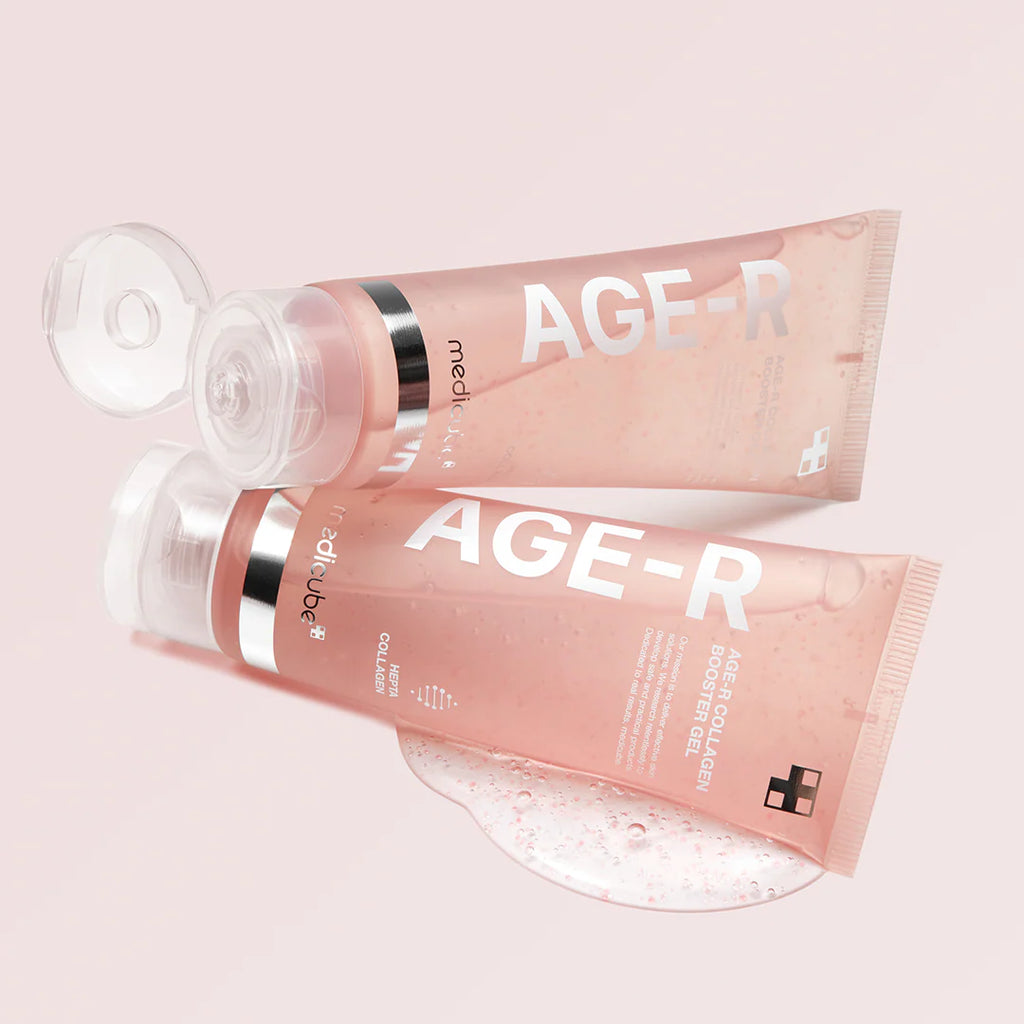 Two pink tubes of 'AGE-R' cream on a light pink background